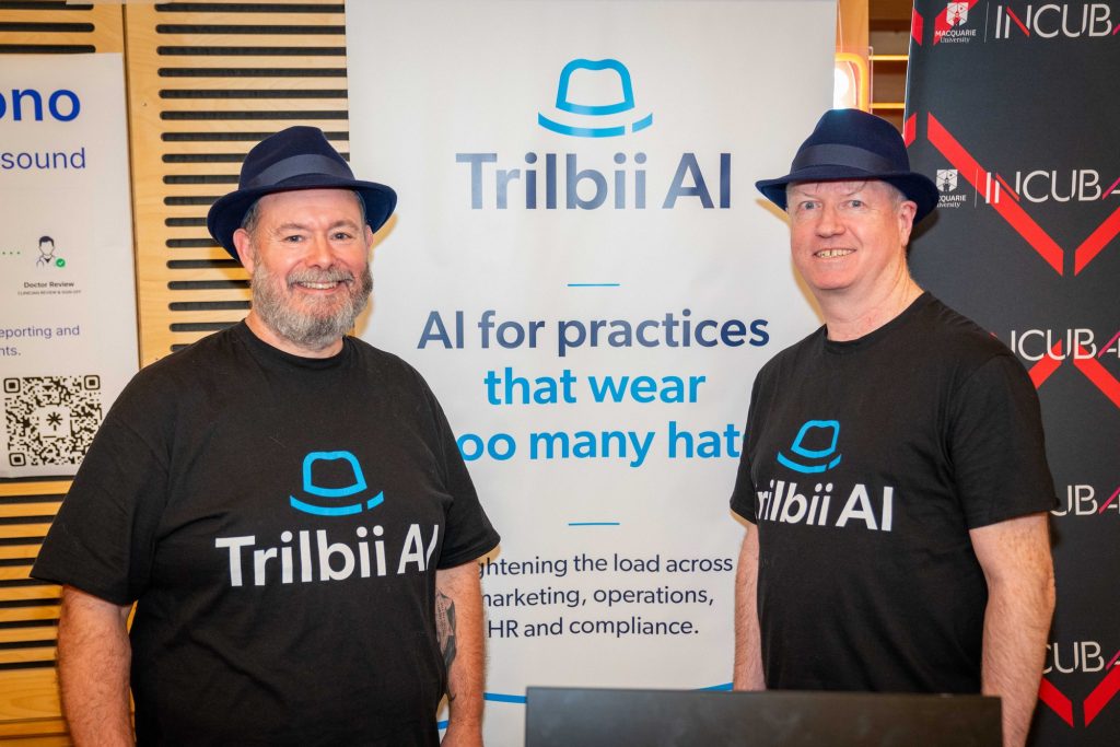 Two members of the Trilbii AI team standing in front of the Trilbii AI banner at the Macquarie University Incubator Demo Day