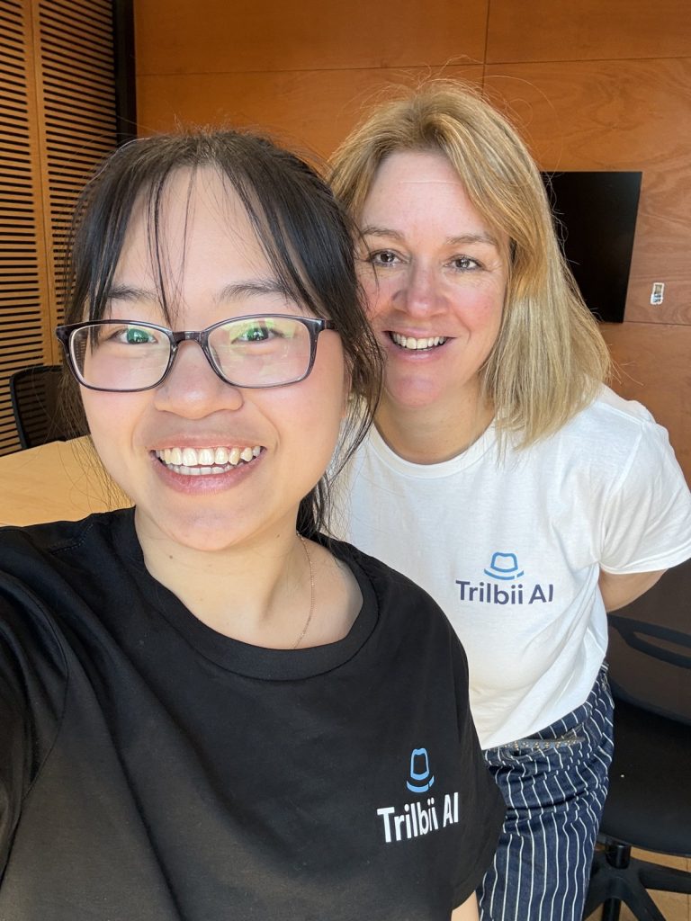 Trilbii AI intern Binh with founder Carolyn S Dean, both wearing Trilbii AI shirts